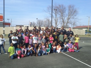 Former Mizzou football players take a group photo with children from the Columbia, Mo. Boys and Girls Club Friday, April 5, 2013.